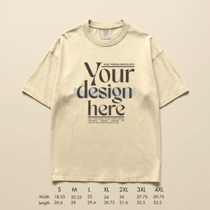 May include: Cream-colored t-shirt with the text "Your design here" in a bold, black font. The shirt has a crew neck and short sleeves. Size chart with width and length measurements in inches is at the bottom.