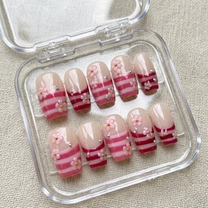 Y2K-esthetiek: roze en witte strepen op de kunstnagels, minimalistische French manicure, zuurstokpatroon, strass-details, lange kunstnagels op maat.
