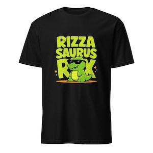 Puede incluir: Camiseta negra con un dinosaurio de dibujos animados verde con gafas de sol y las palabras "Rizza Saurus Rex" en amarillo y verde. El dinosaurio está sentado en un rectángulo naranja.