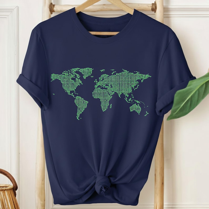 May include: Navy blue t-shirt featuring a green world map design. The map is composed of a pattern of small, repeating shapes. The shirt is made of a soft material and has short sleeves. The shirt is knotted at the waist.