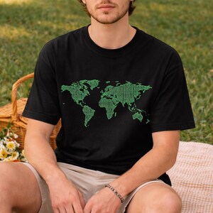 May include: Black t-shirt featuring a green world map design composed of binary code. The graphic covers the front of the shirt, showcasing continents and landmasses. The shirt is a casual, short-sleeved style.