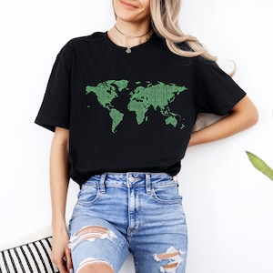 May include: Black t-shirt featuring a green binary code world map design. The graphic is a detailed representation of the continents and oceans. The shirt is made of a soft material and is suitable for casual wear.