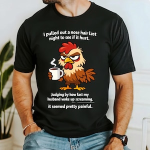Puede incluir: Camiseta negra con un dibujo animado de un pollo sosteniendo una taza de café. El pollo es rojo, marrón y amarillo. El texto de la camiseta dice: "Me arranqué un pelo de la nariz anoche para ver si dolía. A juzgar por la rapidez con la que mi marido se despertó gritando. Parecía bastante doloroso."