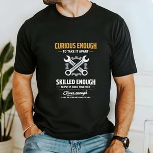 May include: Black t-shirt with the text "Curious Enough to Take It Apart, Skilled Enough to Put It Back Together, Clever Enough to Hide the Extra Parts When I'm Done." Features crossed wrenches in a gray and white design.