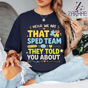 May include: A navy blue t-shirt featuring the text "HELLO, WE ARE THAT SPED TEAM THEY TOLD YOU ABOUT" in yellow, blue, and green. The design includes puzzle pieces, a pencil, and speech bubbles.