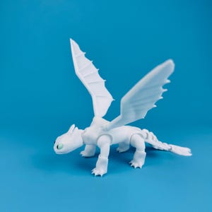 May include: A white dragon figurine with articulated joints and large, spread wings. The dragon has a long tail and green eyes, set against a solid blue background. This collectible toy is a fantasy creature.