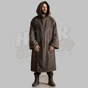 May include: A brown hooded cloak with long sleeves. The cloak is made of a textured fabric and reaches to the ankles. The person in the image is wearing dark boots. The background is a solid gray color.