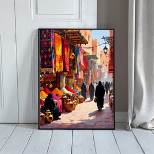 May include: A framed print depicting a vibrant marketplace scene. Colorful textiles hang overhead, and stalls display spices in various hues. Figures in black robes walk along a cobblestone street, with brass pots and lanterns adding to the ambiance. The artwork evokes a sense of a bustling, exotic location.