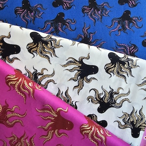 May include: Fabric samples with repeating octopus patterns. The octopuses are black with pink, gold, and brown tentacles, set against blue, white, and pink backgrounds. The fabric is folded, showing the different colors and designs.