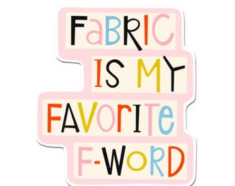 May include: A pink sticker with the words "FABRIC IS MY FAVORITE F-WORD" in colorful block letters. The sticker has a white border and a playful, whimsical design, perfect for crafters and fabric enthusiasts.