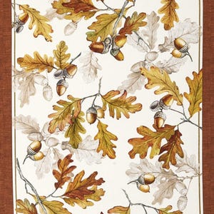 May include: A white background with a pattern of brown and yellow oak leaves and acorns. The leaves are in various shades of brown and yellow, and the acorns are a light brown color.