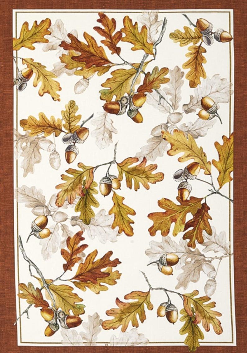May include: A white background with a pattern of brown and yellow oak leaves and acorns. The leaves are in various shades of brown and yellow, and the acorns are a light brown color.