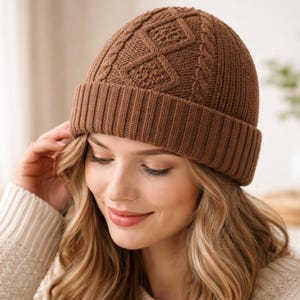 May include: A brown knit beanie with a ribbed brim and a cable-knit diamond pattern on the crown. The hat is a warm, neutral color, suitable for cold weather. The beanie is made of a soft, textured material.