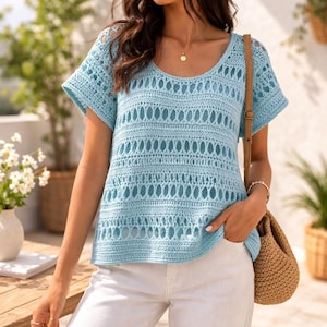 May include: A light blue crochet top with short sleeves and a scoop neckline. The top has an open, textured design with horizontal rows of eyelet patterns. The garment is paired with white trousers and a woven shoulder bag.