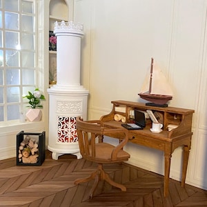 May include: Miniature wooden desk with a small sailboat, laptop, and books. A wooden chair sits in front of the desk. A white fireplace and a window with a plant are in the background. The floor has a herringbone pattern.