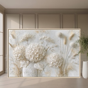 May include: A rectangular wall art piece featuring a textured, three-dimensional relief of white hydrangea flowers and dried grasses in a vase. The artwork is set against a white background with subtle beige and cream accents, framed in a light wood.