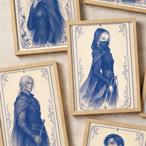 Peut inclure: Une collection de cinq tirages d'art encadrés présentant des illustrations à l'encre bleue de personnages fantastiques. Chaque portrait est inséré dans un cadre en bois clair et représente des figures en tenue détaillée, avec capes, capuches et épées.