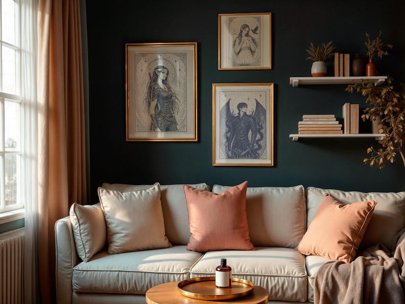 May include: A living room scene featuring a cream-colored sofa with peach-colored pillows and a round wooden coffee table. Above the sofa, three framed art prints with gold frames hang on a dark teal wall. The room is decorated with plants and books.
