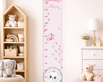 May include: Pink height chart with a crown, butterfly, and cat design. The chart measures up to 140 cm and features the name "Annie". Decorative elements include pink flowers and a wooden hanging bar.