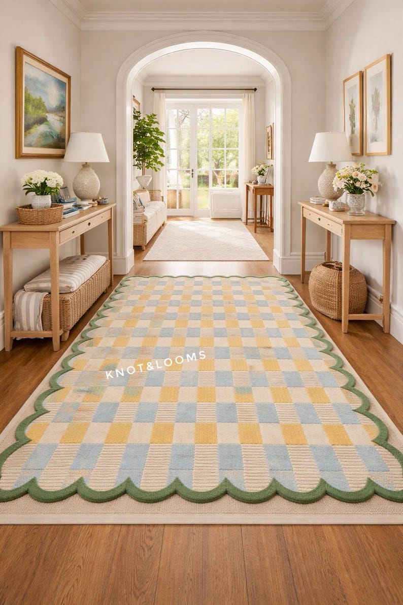 May include: A rectangular rug with a checkered pattern in yellow and pale blue, edged with a green scalloped border. The rug is in a hallway with wooden flooring and furniture. The text "KNOT & LOOMS" is visible on the rug.