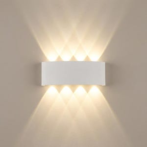 May include: A white, rectangular wall sconce with multiple light beams radiating outwards. The fixture is mounted on a neutral-colored wall, creating a modern lighting effect. The light beams are warm and bright.