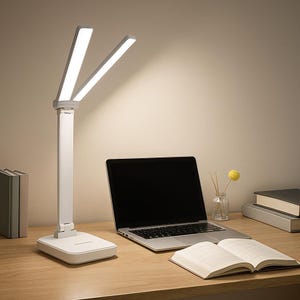 May include: A white LED desk lamp with two adjustable light panels. The lamp is on a wooden desk next to a laptop and an open book. The lamp's design is modern and minimalist, suitable for a home office or study space.