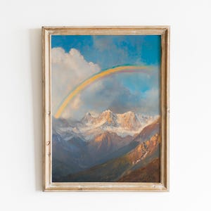 Puede incluir: Una pintura de paisaje enmarcada representa un arcoíris sobre montañas cubiertas de nieve. La obra de arte presenta un arcoíris vibrante contra un cielo azul con nubes blancas. Las montañas están pintadas en tonos de azul, marrón y blanco.