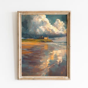 May include: A framed landscape painting depicts a coastal scene with a castle on a hill under a dramatic sky. The artwork features a beach with reflections of the sky and clouds, rendered in shades of gold, blue, and brown.