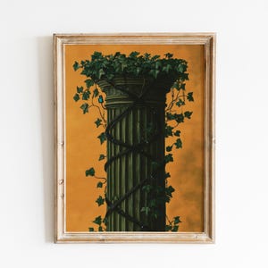 May include: A framed art print depicting a classical column adorned with dark vines and topped with green foliage. The column is set against an orange backdrop, and the artwork is enclosed within a wooden frame.