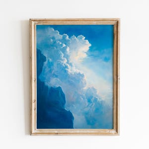 May include: Framed art print featuring a vibrant depiction of a cloudy sky. The artwork showcases a gradient of blues, with fluffy white clouds and a hint of sunlight. The frame is a light, natural wood color.