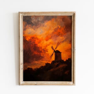 May include: Framed artwork depicting a windmill on a hill against a dramatic sunset. The sky is filled with fiery orange and red clouds, contrasting with the dark silhouette of the mill. The frame is a light, natural wood.