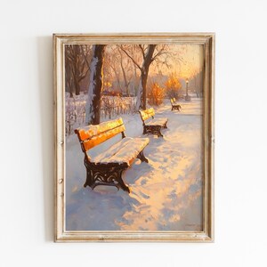 May include: Framed winter landscape painting featuring park benches covered in snow. The benches have orange seats and ornate black metal frames. The scene is bathed in warm sunlight, with trees and a pathway visible in the background.