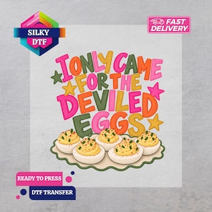May include: A DTF transfer sheet featuring the colorful text I ONLY CAME FOR THE DEVILED EGGS in pink, yellow, orange, and green, accented by stars and a platter of five deviled eggs topped with green herbs and red paprika sprinkles.