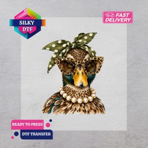 May include: A DTF transfer featuring a duck wearing leopard print sunglasses, a pearl necklace, and a green headscarf with white polka dots. The design includes the text SILKY DTF, FAST DELIVERY, READY TO PRESS, and DTF TRANSFER in various locations.