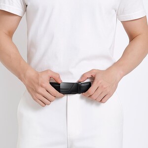 Puede incluir: Cintur&oacute;n de cuero negro con una hebilla geom&eacute;trica moderna. El cintur&oacute;n se est&aacute; abrochando, mostrando el dise&ntilde;o de la hebilla. El cuero parece texturizado, y el estilo general es minimalista y contempor&aacute;neo.