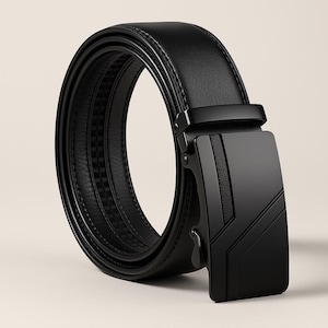 Op de afbeelding: Een zwarte leren riem met een moderne, geometrische gesp. De riem is opgerold tot een lus, waarbij de gladde textuur en het ingewikkelde ontwerp van de gesp worden getoond. De gesp heeft een matte zwarte afwerking.