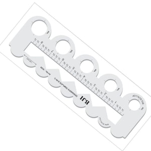 Puede incluir: Plantilla de diseñador de plástico blanco con regla y bordes festoneados. La plantilla incluye medidas en pulgadas y el texto "BJI DESIGNER'S TEMPLATE (5-IN-1)". La plantilla mide 3,18 cm de ancho.
