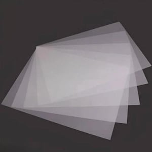 May include: A stack of multiple rectangular sheets of translucent, semi-transparent material. The sheets are layered and fanned out slightly, showing a clear, frosted appearance with smooth edges and a thin, flexible, and lightweight construction.
