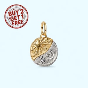 May include: A two-tone pendant with a gold sun and a silver moon and stars design. The pendant has a small diamond and a gold loop for a chain. The pendant is round and has a textured surface.