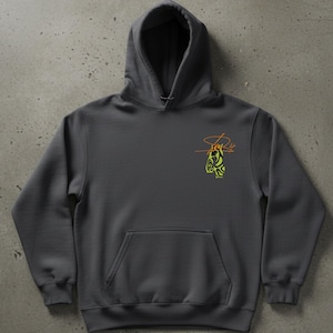May include: A charcoal gray hoodie with a kangaroo pocket and a drawstring hood. The hoodie features a small, abstract design in yellow and orange on the upper left chest. The design appears to be a stylized signature or logo.
