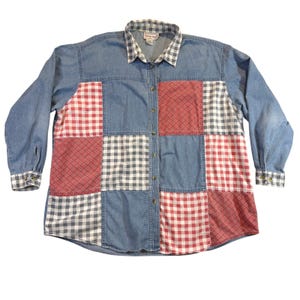 Könnte beinhalten: Ein langärmeliges Jeanshemd mit Patchwork-Design. Das Hemd hat Quadrate aus blauem Denim, rot-weißem Vichy-Karo und rot gemustertem Stoff. Der Kragen und die Manschetten haben ein grau-weißes Karomuster.
