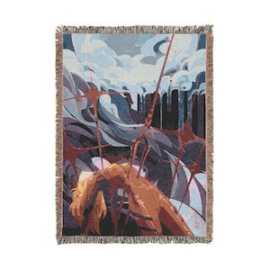 May include: Woven throw blanket featuring an abstract illustration in shades of brown, blue, and gray. The artwork depicts a figure with long hair, surrounded by abstract shapes and a cloudy sky. The blanket has a fringed edge.