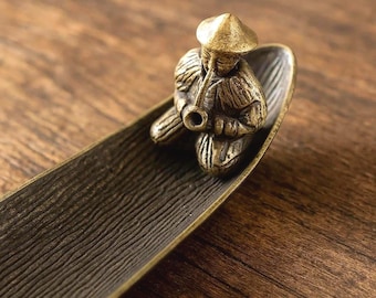 Vintage japanese metal incense holder depicting a fishing boat.