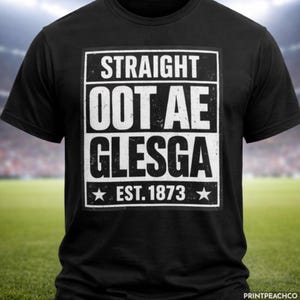 May include: Black t-shirt featuring a white rectangular design with the text "STRAIGHT OOT AE GLESGA" and "EST. 1873" with star accents. The shirt is shown on a green field with a blurred stadium in the background.