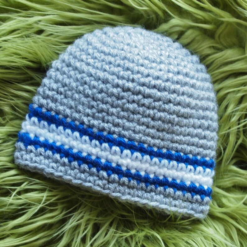 May include: Gray crocheted beanie with a blue and white stripe.