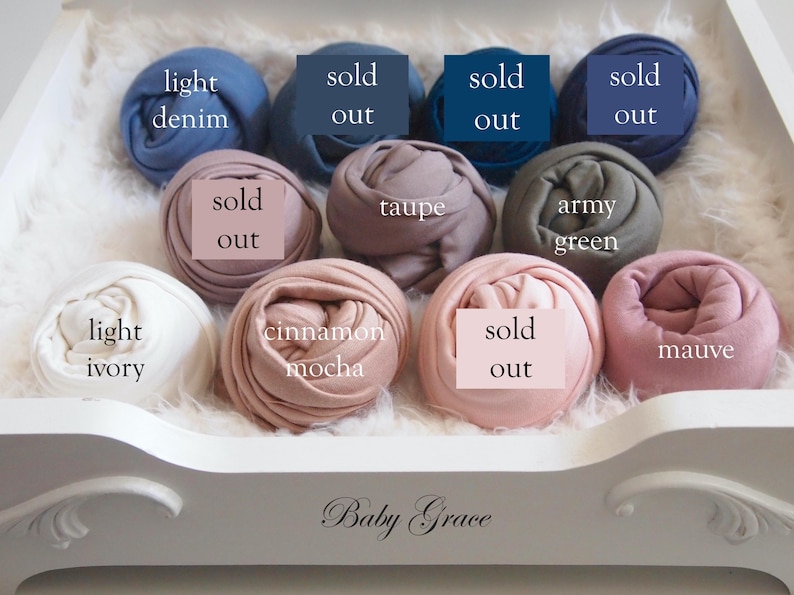 May include: A selection of rolled fabric in various colors, including light denim, taupe, army green, light ivory, cinnamon mocha, and mauve. Some items are marked "sold out". The items are arranged in a white decorative tray with the text "Baby Grace".