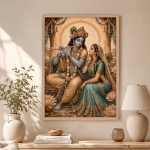 May include: A framed wall art print depicting a blue-skinned deity playing a golden flute while seated beside a woman in a teal and gold sari. The scene is set within an ornate architectural space adorned with lotus flowers and a glowing halo.