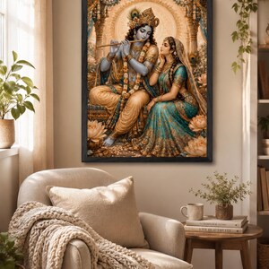 May include: A framed wall art print depicting the Hindu deities Krishna and Radha. Krishna, with blue skin, plays a golden flute while seated. Radha, in a teal and gold sari, sits beside him. The scene features lotus flowers and ornate pillars.