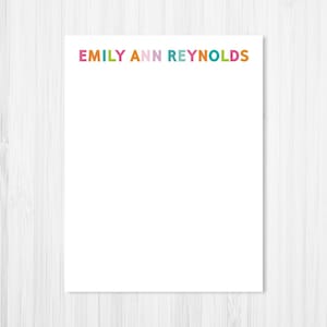 May include: White notepad with the name "EMILY ANN REYNOLDS" printed in colorful letters at the top.