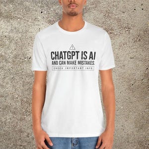 Puede incluir: Una camiseta blanca de manga corta con un estampado gráfico negro que dice: CHATGPT IS AI AND CAN MAKE MISTAKES. CHECK IMPORTANT INFO. El diseño incluye un pequeño icono de advertencia triangular con un signo de exclamación.